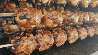 Pollos asados girando en el asador de Kilo y Cuarto